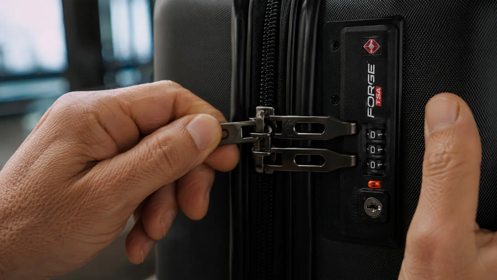 Close-up of a luggage lock showing the open-alert indicator flag in the triggered position