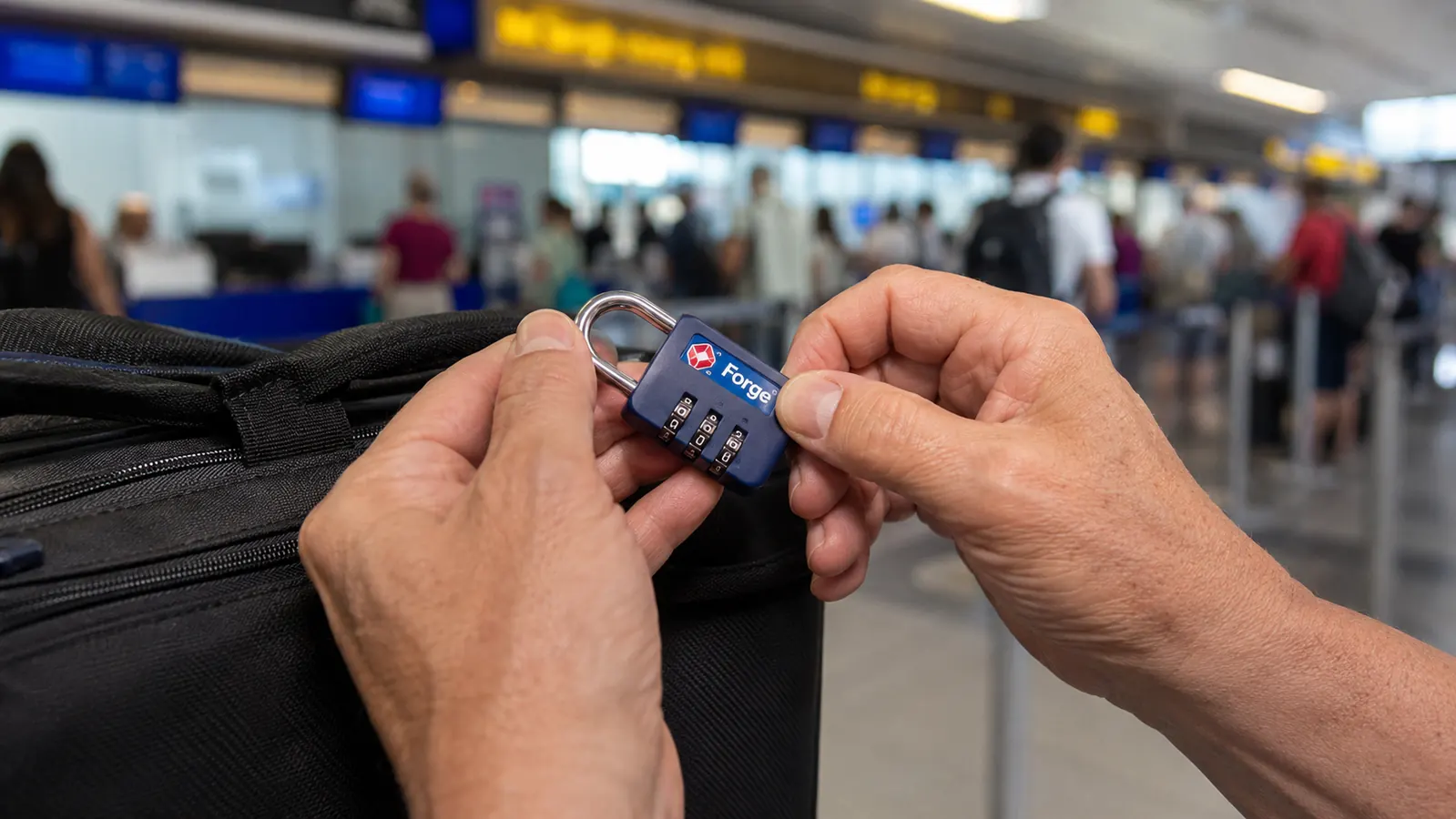 Traveler setting a new combination on a Forge lock at an airport check-in counter